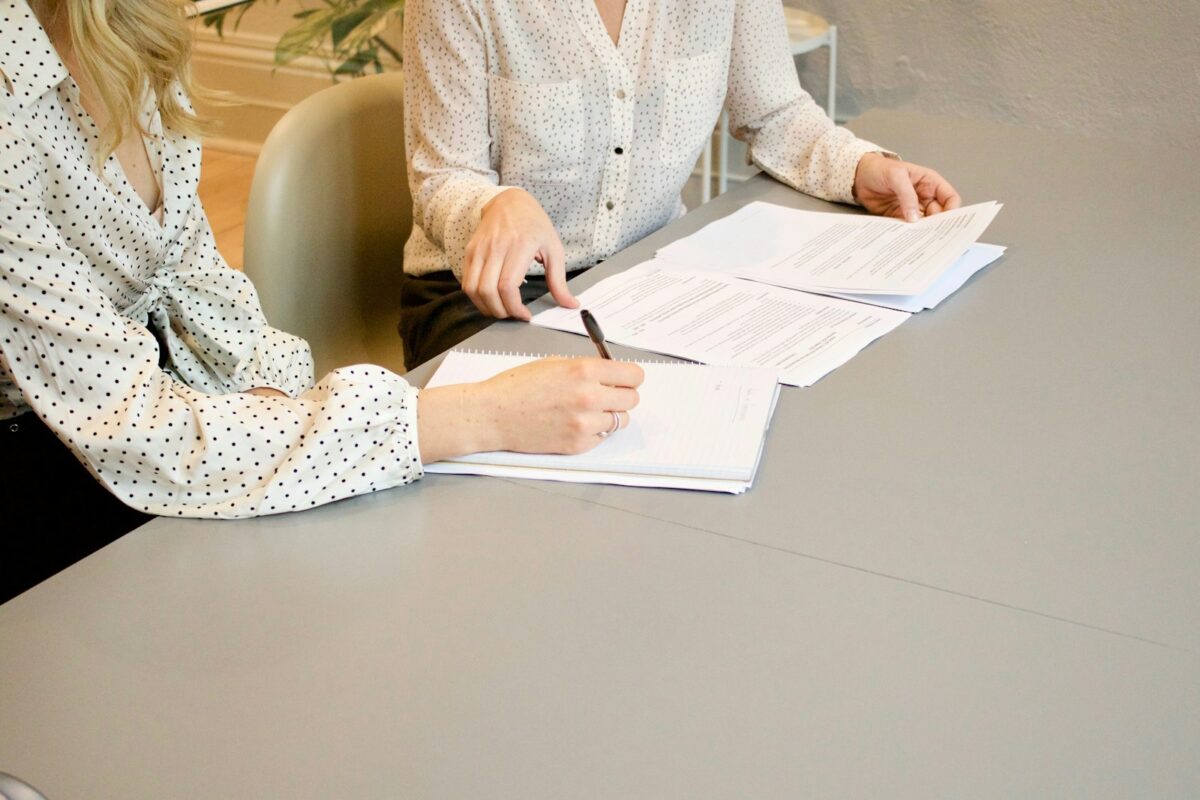 Duas pessoas revisando contrato de consultoria financeira sobre a mesa