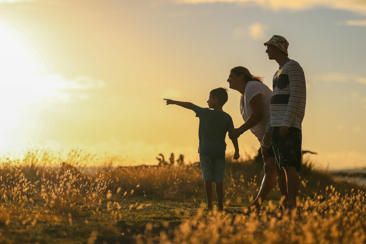 Familia observando o horizonte ao entardecer, simbolizando legado entre geracoes