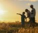 Familia observando o horizonte ao entardecer, simbolizando legado entre geracoes